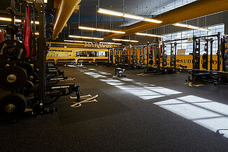 View of the Millersville strength center offered to athletes to continue improving their athletic performance. A number of weight racks are available to athletes, allowing for a variety of exercises to be performed. REGUPOL aktivpro roll flooring is featured throughout the facility.