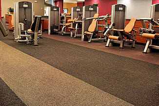 Alternating color rolls of REGUPOL aktiv flooring helps to promote the brand identity of Horsham Athletic Club. Equipment is positioned on the perimeter of the facility walls.