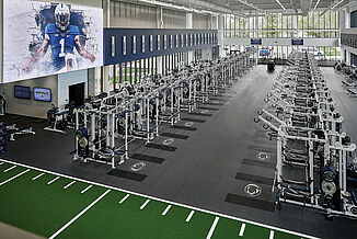 Penn State University's Football Weight Room Overhead view of Penn State's football weight room with weight racks, benches, and turf area, showcasing the Penn State logo within REGUPOL aktivpro roll flooring and crash zones.