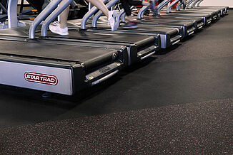 UFC Gym - Treadmills and REGUPOL aktiv Flooring A row of treadmills sitting on REGUPOL aktiv rolled rubber flooring in the UFC Gym in Lancaster. An athlete exercises on the treadmill.