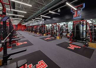 View of the Texas Tech Olympic Weight Room, offering a number of weight tracking racks for athletes to perform workouts to strengthen their performance.
