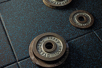 A set of weights rests directly on a REGUPOL aktivpro flooring at Temple University fitness center.