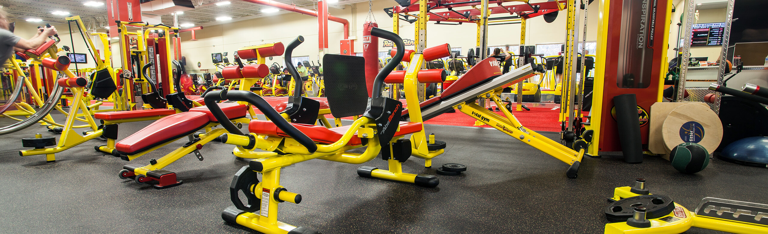 Retro Fitness Stroudsburg with vibrant yellow and red equipment for fitness members, featuring REGUPOL rubber floors.